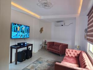 a living room with a couch and a flat screen tv at The Venue by Radlett in Tuguegarao City