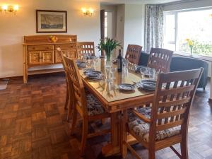 une salle à manger avec une table et des chaises en bois dans l'établissement Riverside, à Truro 9 autres photos