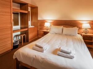 a bedroom with a bed with two towels on it at Macallan Lodge - Uk49119 in Feshiebridge +7 photos