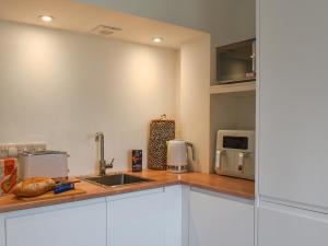 a kitchen with a sink and a microwave at Garden Cottage in Thornton Dale