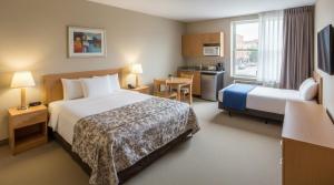 a hotel room with two beds and a kitchen at Arsuz yas Apart in Arsuz