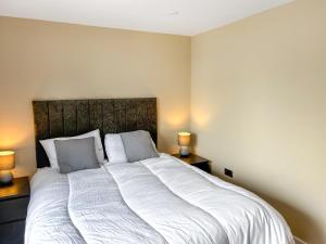 Un dormitorio con una gran cama blanca con dos lámparas. en Harbour Heights, en Bridlington