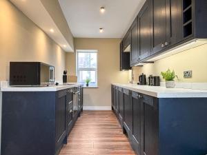 Una cocina grande con gabinetes negros y piso de madera. en Harbour Heights, en Bridlington