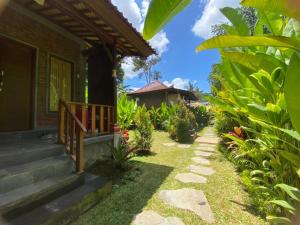 a pathway leading to a house with a porch at Kamanaya Ubud in Ubud