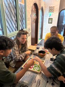 a group of people sitting around a table at Zion Backpackers Hostel in Guwahati