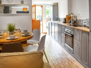 a kitchen with a table and chairs in a kitchen at Waverley Cottage in Mundesley