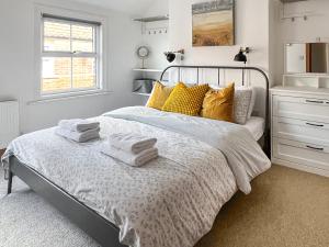 a bedroom with a bed with towels on it at Waverley Cottage in Mundesley