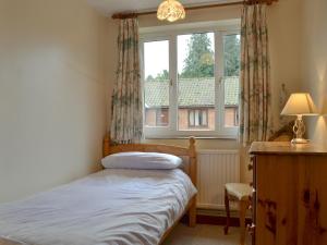 a small bedroom with a bed and a window at Stable Cottage 5 - Ukc3744 in Bawdeswell