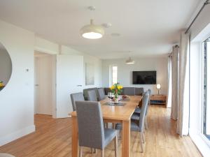 a dining room and living room with a table and chairs at Fox Lodge in Crantock