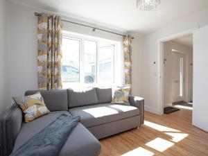 a living room with a couch and a window at Fox Lodge in Crantock