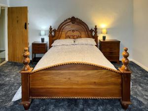 a large wooden bed in a bedroom with two night stands at Low Houses Farmhouse in Newbiggin