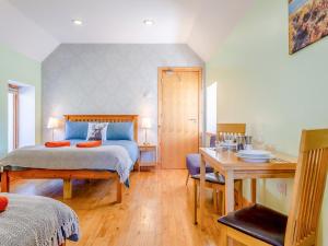 a bedroom with a bed and a desk and a table at Quinag Studio Apartment - Uk49098 in Inchnadamph