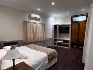 a bedroom with a bed and a flat screen tv at Hacienda Don Justo Hotel Boutique Spa in Colón