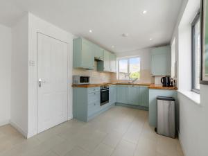 a kitchen with blue cabinets and a white door at Beach House in Seaford
