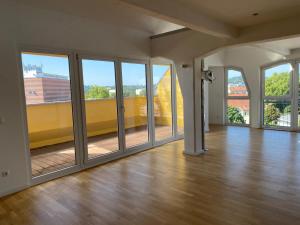 an empty room with large windows and a wooden floor at Vorverkauf Penthouse Loft Bamberg in Bamberg +15 photos