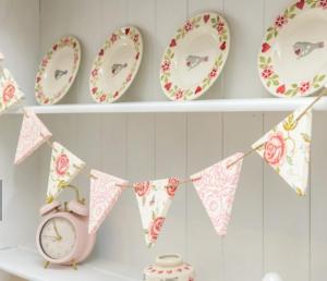 a shelf with plates and a clock on it at Charming country cottage at a Victorian Station in Alnwick