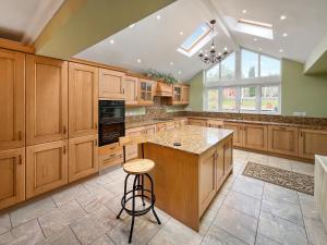 a large kitchen with wooden cabinets and a island at Violet Bank in Cockermouth