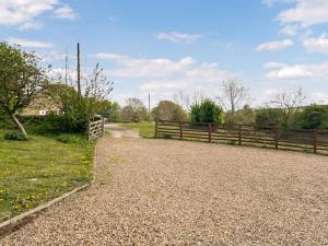 a fence next to a dirt road next to a field at Middle Farm in Durham