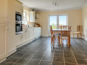 a kitchen with a table and chairs and a kitchen with white cabinets at Middle Farm in Durham +10 photos