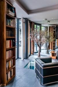 een woonkamer met een boekenplank en een bank bij Art Hotel Eiffel in Parijs