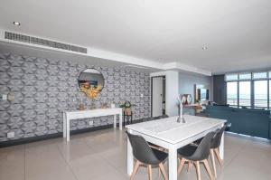 a dining room with a white table and chairs at Executive Apartment with Ocean Views in Blouberg in Big Bay +20 photos