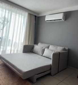 a couch in a living room with a window at Varandas Praia de Ponta Negra in Natal