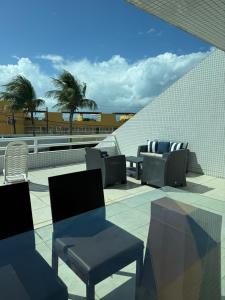 a patio with chairs and tables on a roof at Varandas Praia de Ponta Negra in Natal