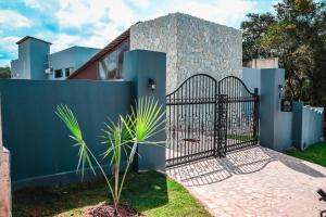a blue fence with a gate in front of a house at Pousada Sierra in Areia