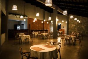 a dining room with tables and chairs and lights at Pousada Sierra in Areia
