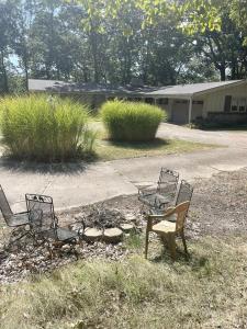 three chairs and a table in a yard at Peaceful Cabin Getaway Overlooking Tuscarawas River Valley in New Philadelphia, Ohio in New Philadelphia