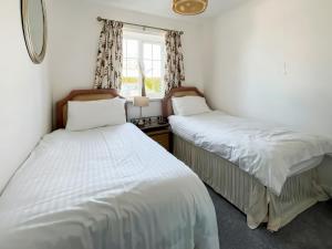 two beds in a room with a window at Bramble - Uk49172 in Burgh le Marsh +3 photos