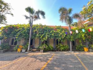 a building with palm trees and a brick driveway at Clover Homestay in Probolinggo