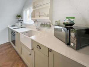 a white kitchen with a sink and a microwave at Lotties Lodge - Uk49905 