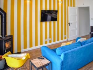 a living room with a blue couch and a fireplace at The Old Hayloft - Uk49680 in Witheridge