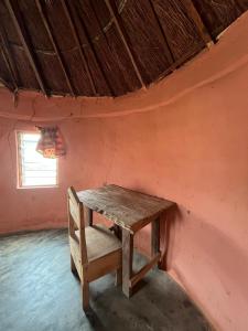 a wooden table in a room with a window at Savannah Lodge in Larabanga