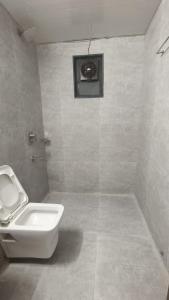 a bathroom with a toilet and a sink at Hotel Ashraya International in Mumbai