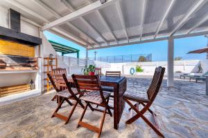 a dining room with a table and chairs and the ocean at Cocoteros Ocean View House in Guatiza +5 photos