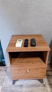 two remote controls sitting on top of a wooden table at Pousada Rancho Dona Lú Comfort in Pereira Barreto