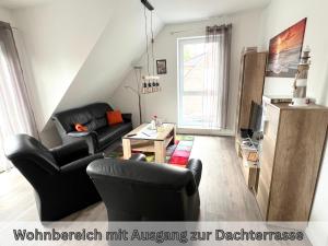 a living room with two black chairs and a table at "Nautilus" Papenburg Dachterrasse Einbauküche Neubau 74 qm Free Wifi 2 Schlafzimmer bis 4 Personen in Papenburg