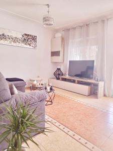 a living room with a large tv and a couch at Casa ryli in Torrevieja
