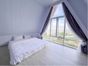 萨兰甘Harmadha Glamping的一间卧室，里面有一张床和一扇大窗户。