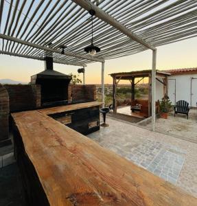 a patio with a wooden table and an outdoor grill at Eco Lodge Lorotuerto in Guanaqueros +8 photos
