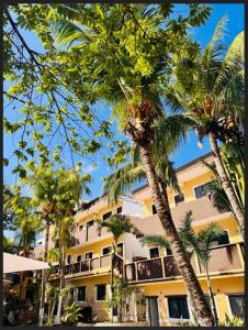 two palm trees in front of a building at Maya Bric in Playa del Carmen