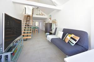 a living room with a blue couch and a tv at Piriac Dumet Appartement Duplex avec exterieur 4 à 6p 500m de la plage in Piriac-sur-Mer