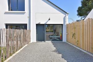 a white house with a gate and a fence at Piriac Dumet Appartement Duplex avec exterieur 4 à 6p 500m de la plage in Piriac-sur-Mer +4 photos