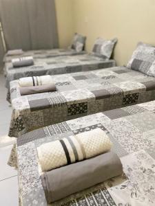 a group of three beds sitting in a room at Pousada Conviver - Unidade 2 in Juazeiro do Norte +11 photos