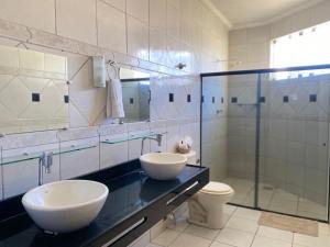 a bathroom with two sinks and a toilet and a shower at Pousada Conviver - Unidade 2 in Juazeiro do Norte