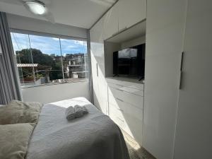a bedroom with a bed and a large window at Raridade Cachoeiro, Apto 2 Qtos, Ar, Ferroviários in Cachoeiro de Itapemirim