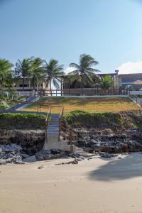 a stairway leading down to a beach with palm trees at Casa Pé na Areia, Praia de Cotovelo Natal RN in Parnamirim