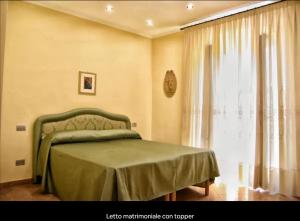 une chambre avec un lit vert et une fenêtre dans l'établissement Casa Beatrice, à Campochiaro